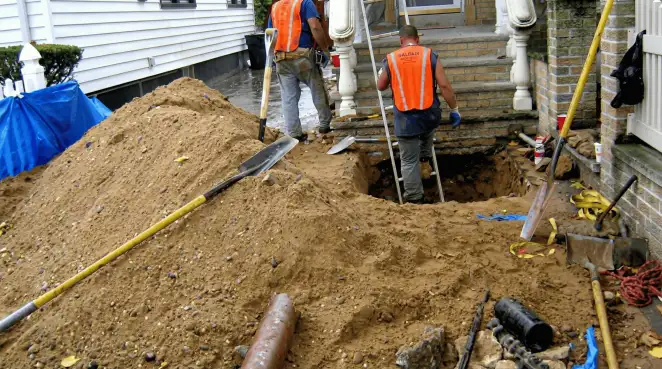 Contractors performing foundation protection and exterior drainage excavation near residential home steps in Duluth, MN
